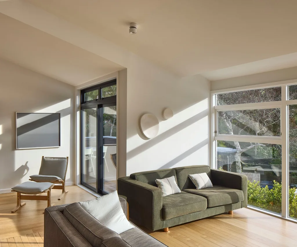 Les portes et fenêtres coulissants terminés dans Matt Flax Pod, complètent le revêtement en médaillon carbonisé sur la nouvelle extension moderniste dans cette maison de Khandallah