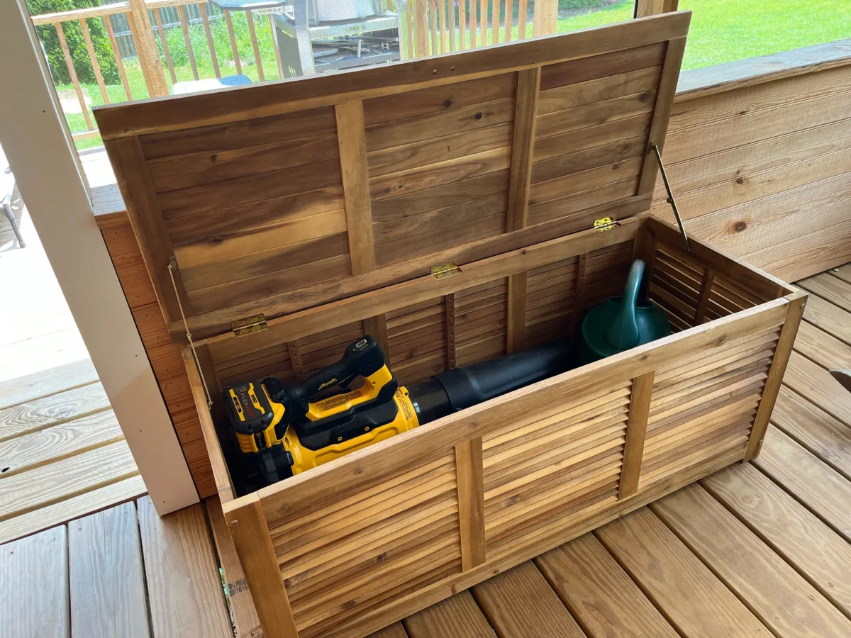 The Tangkula 48-Gallon Acacia Wood Deck Box open on a wooden patio to show its storage capacity