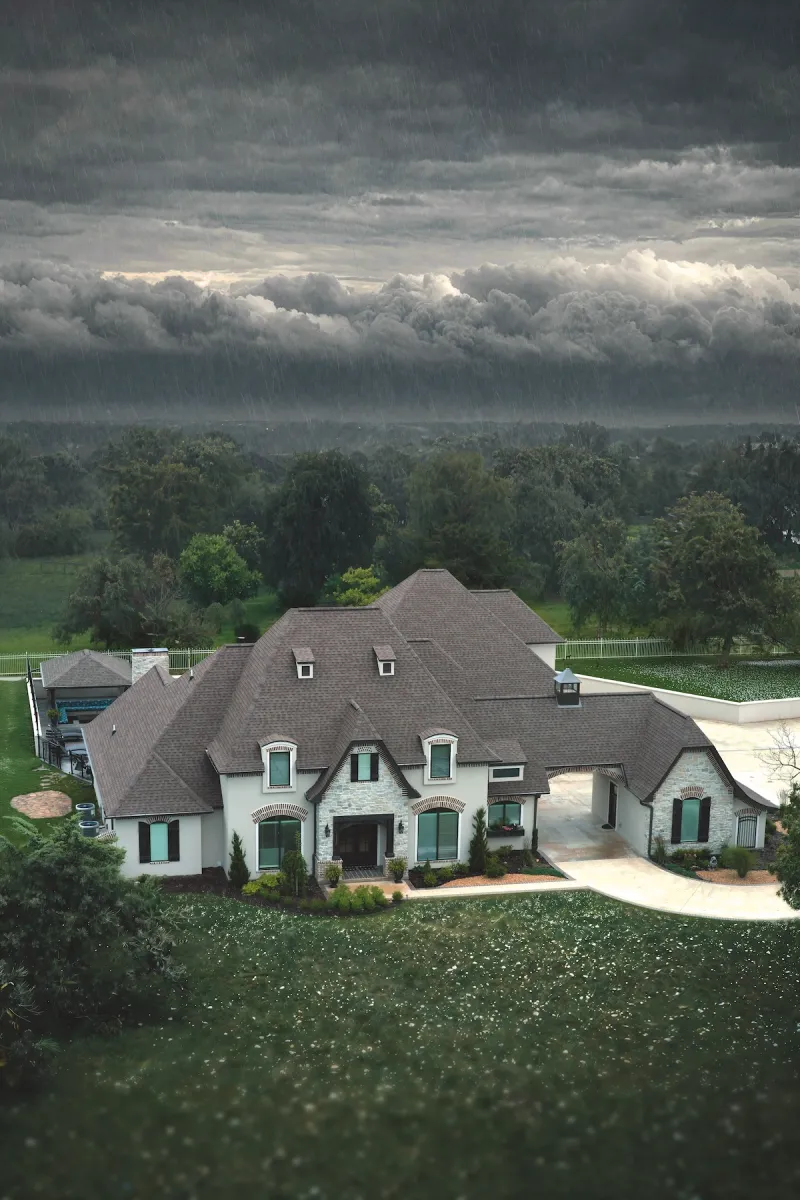 A home in a hail storm with a durable roof with TAMKO HailGuard shingles.