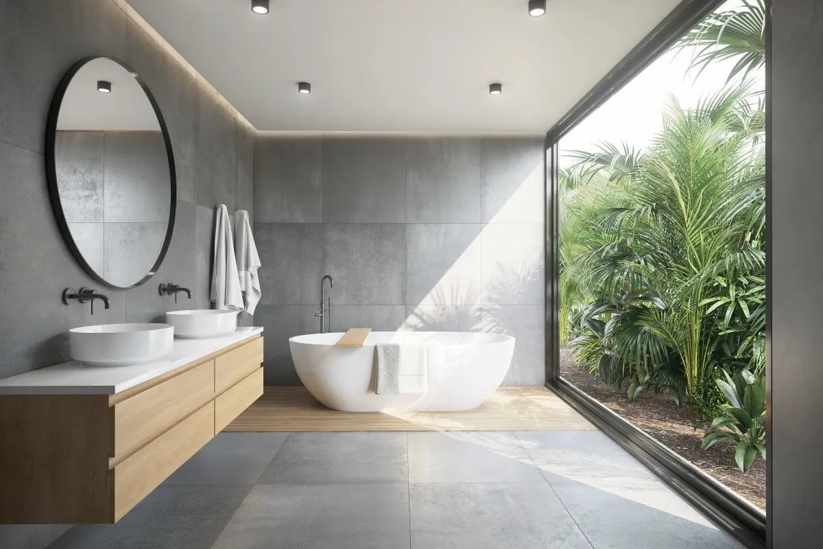 A modern bathroom with a concrete floor and a large window.
