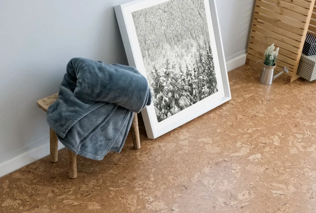 A towel on a stool in a bathroom with cork flooring.