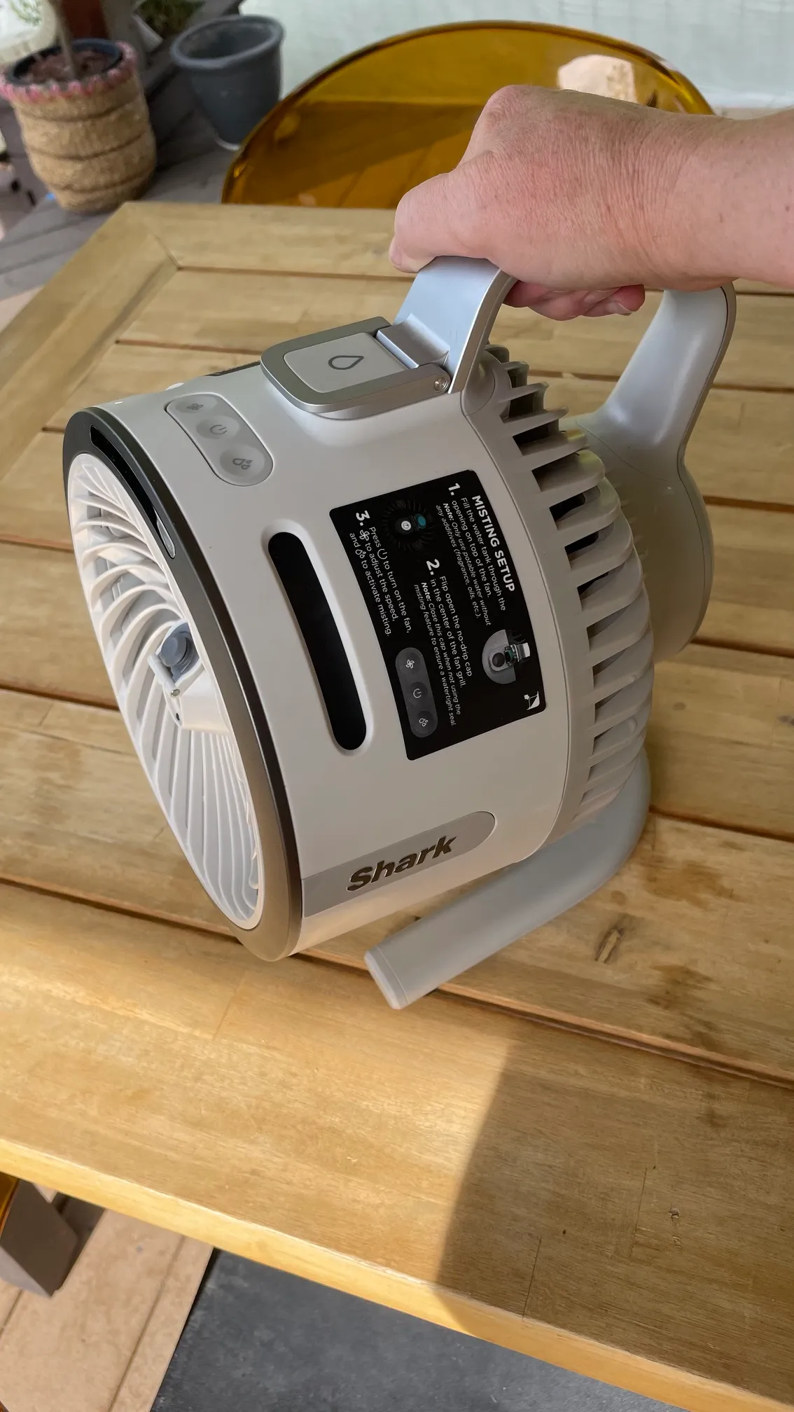 A person using the carry handle on Shark FlexBreeze HydroGo Pro Fan