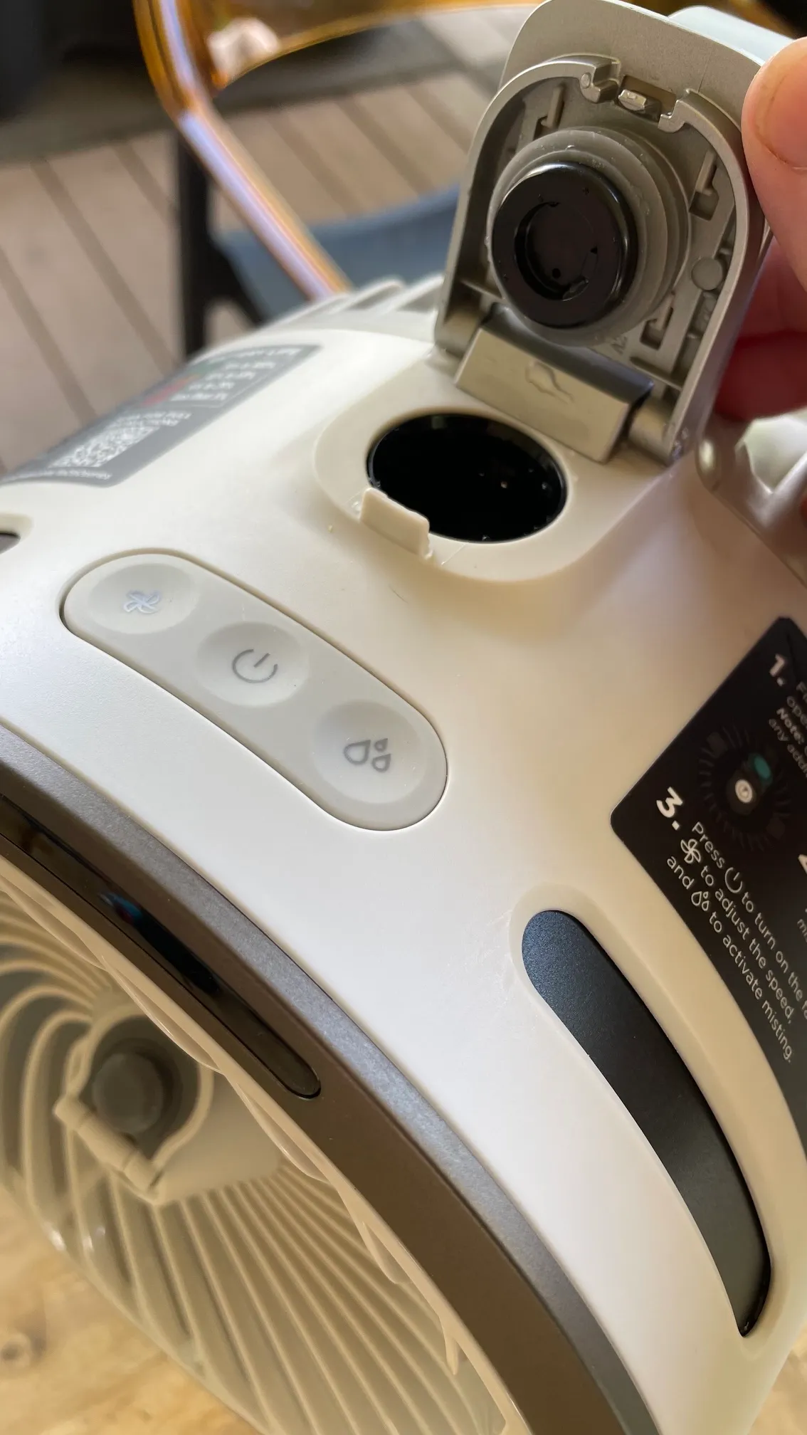 A person holding open the small door on the Shark FlexBreeze HydroGo-Pro Fan for filling