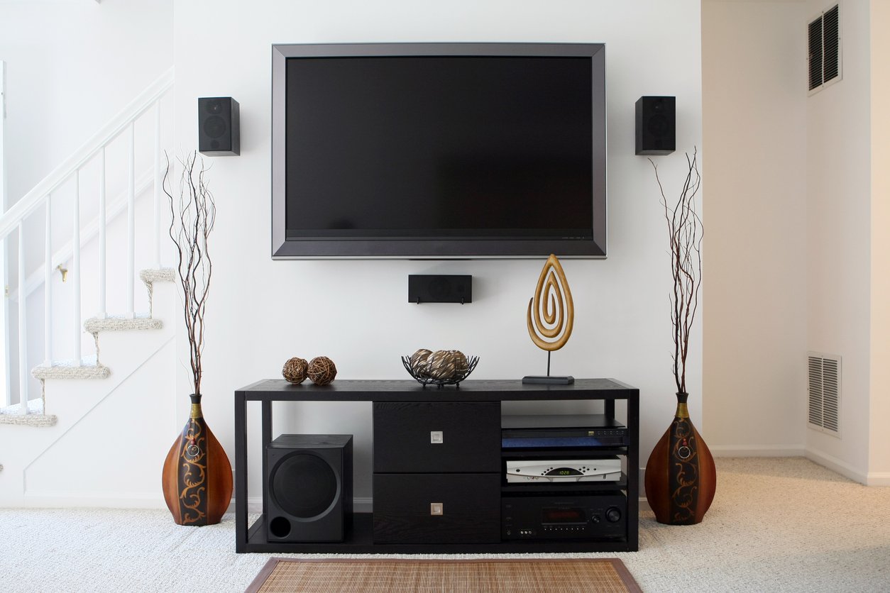 A flat-screen TV mounted to the wall above an entertainment console in a modern living room.