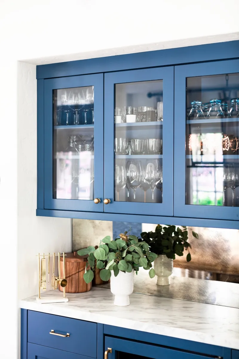 Blue floating wall cabinets with windowed doors.