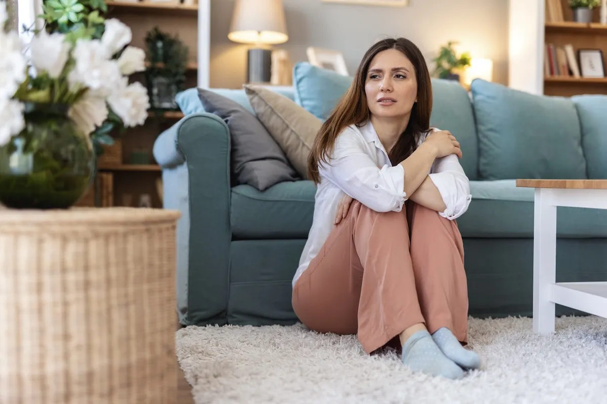 Thinking, sad and woman in home on the floor.