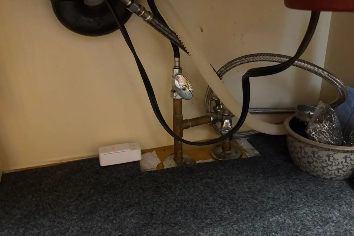 SwitchBot Smart Water Leak Detector alarming under kitchen sink during testing