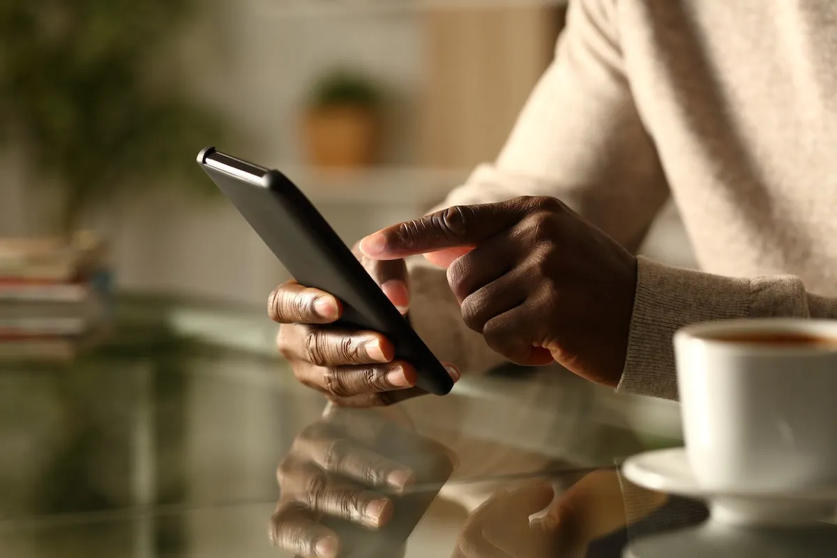 Man's hands checking smart phone at night.