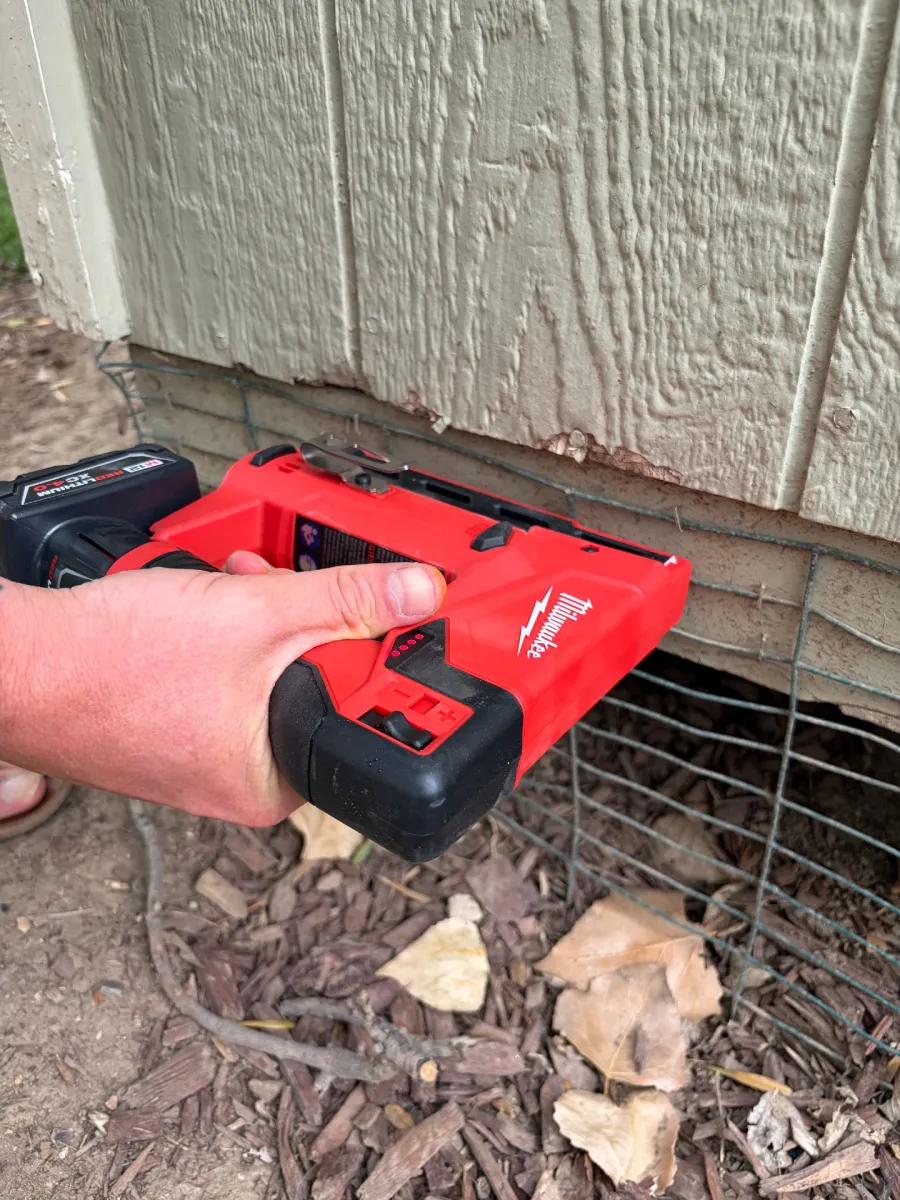 Using the Milwaukee 2447-20 M12 ⅜-Inch Crown Stapler to install animal guard on a shed