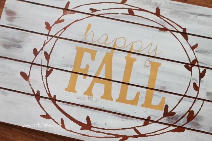 A "Happy Fall" sign made of a wood pallet painted white with fall motifs.