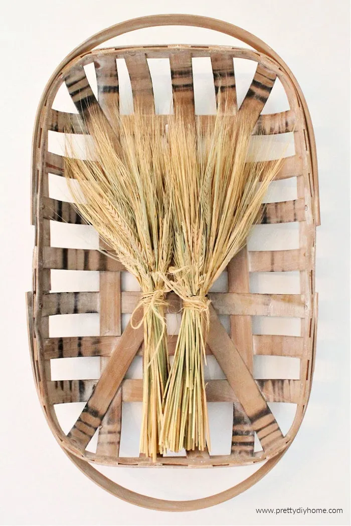 Overhead view of dried wheat stalks in a flat basket.