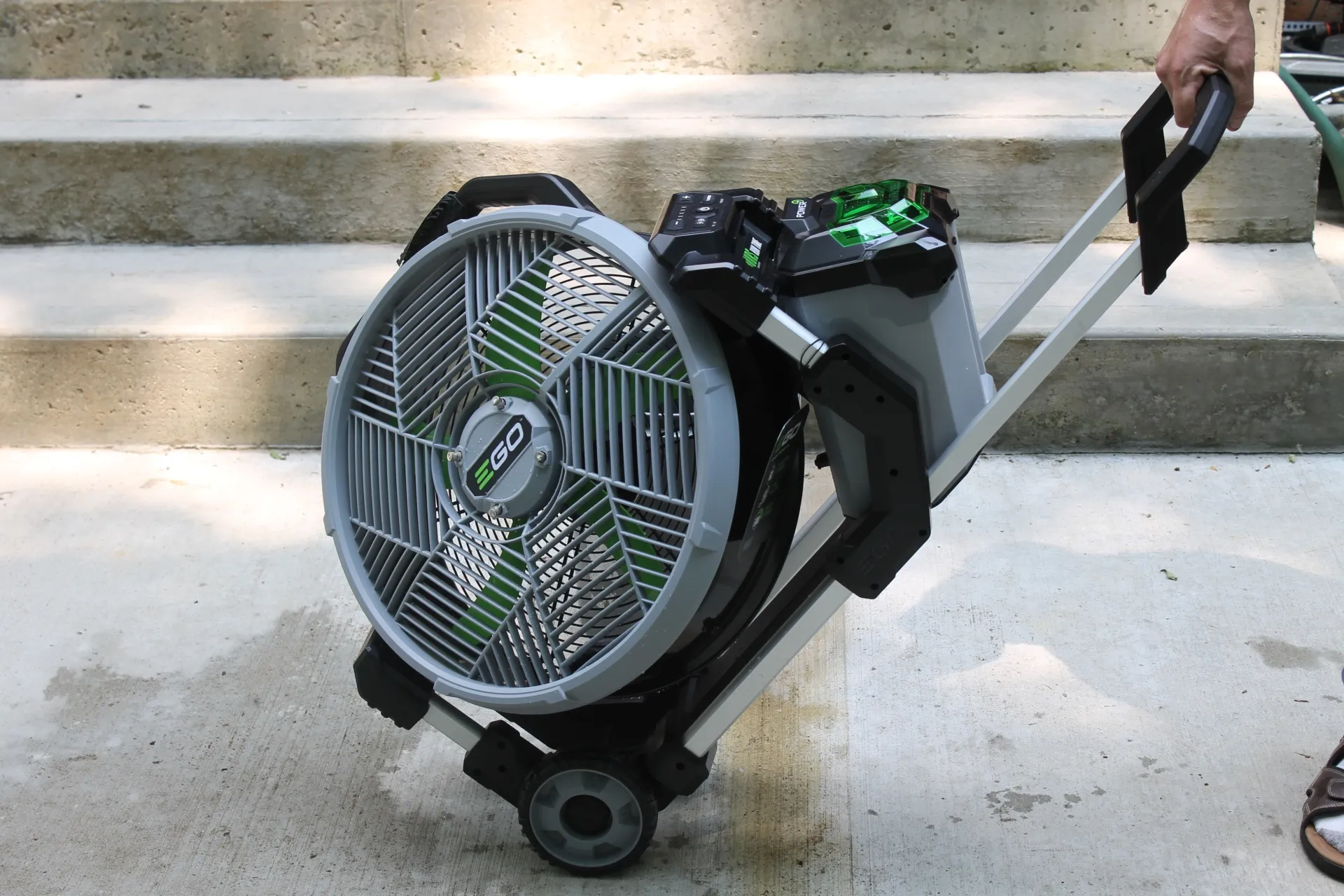 Ego Power Misting Fan on Wheels on concrete patio in front of stairs