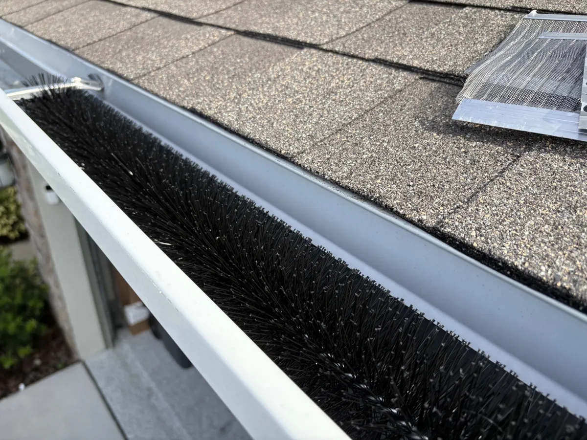 Gutter Brush installed in gutter above garage