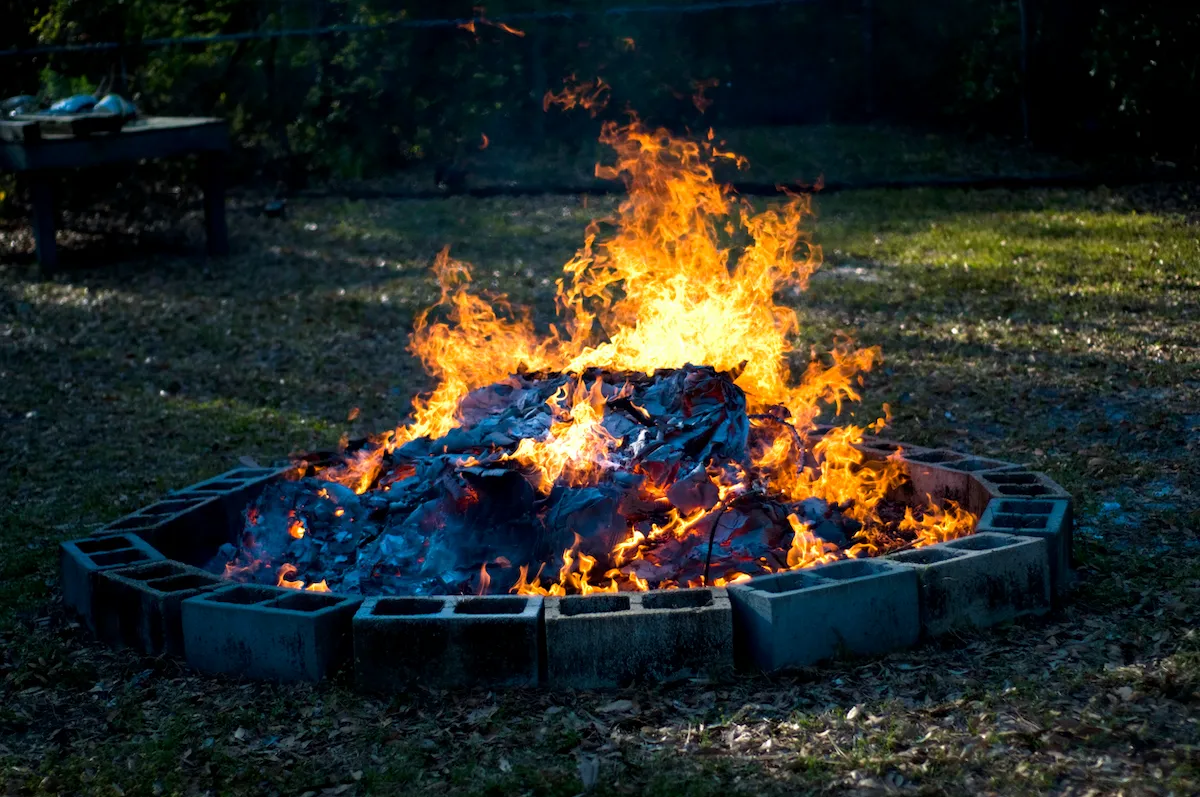An illuminated cinderblock fire pit at night.