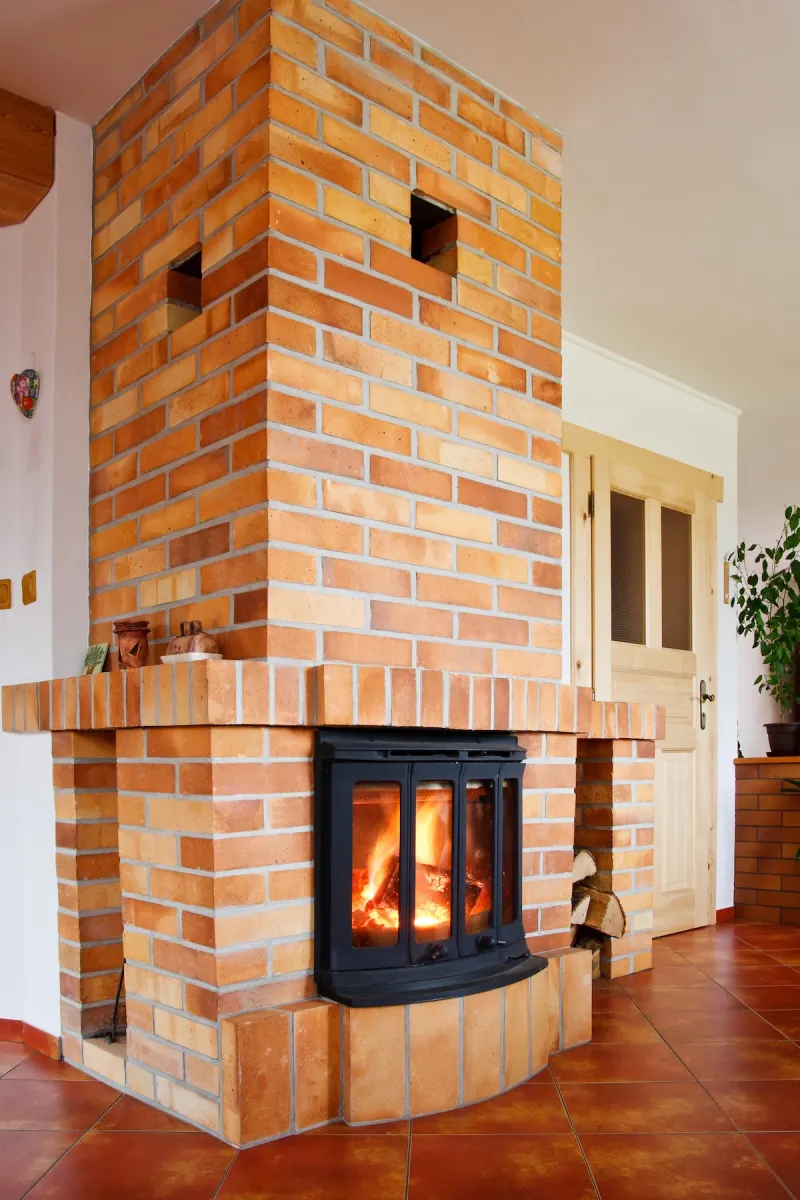 An old wood-burning fireplace with a modern fireplace insert for efficiency.