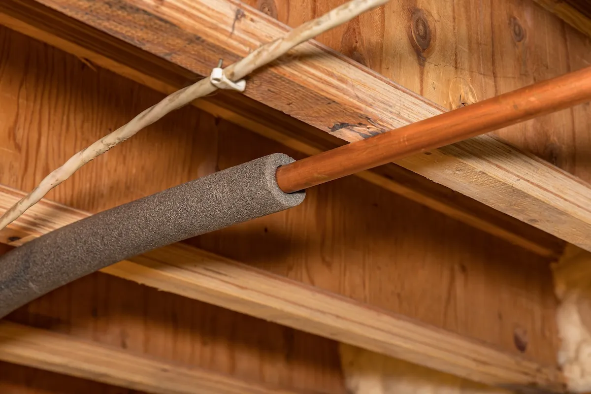 Copper pipes wrapped in foam insulation to prevent freezing.