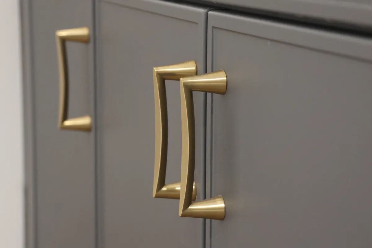 Gold cabinet pulls on putty-colored cabinets.