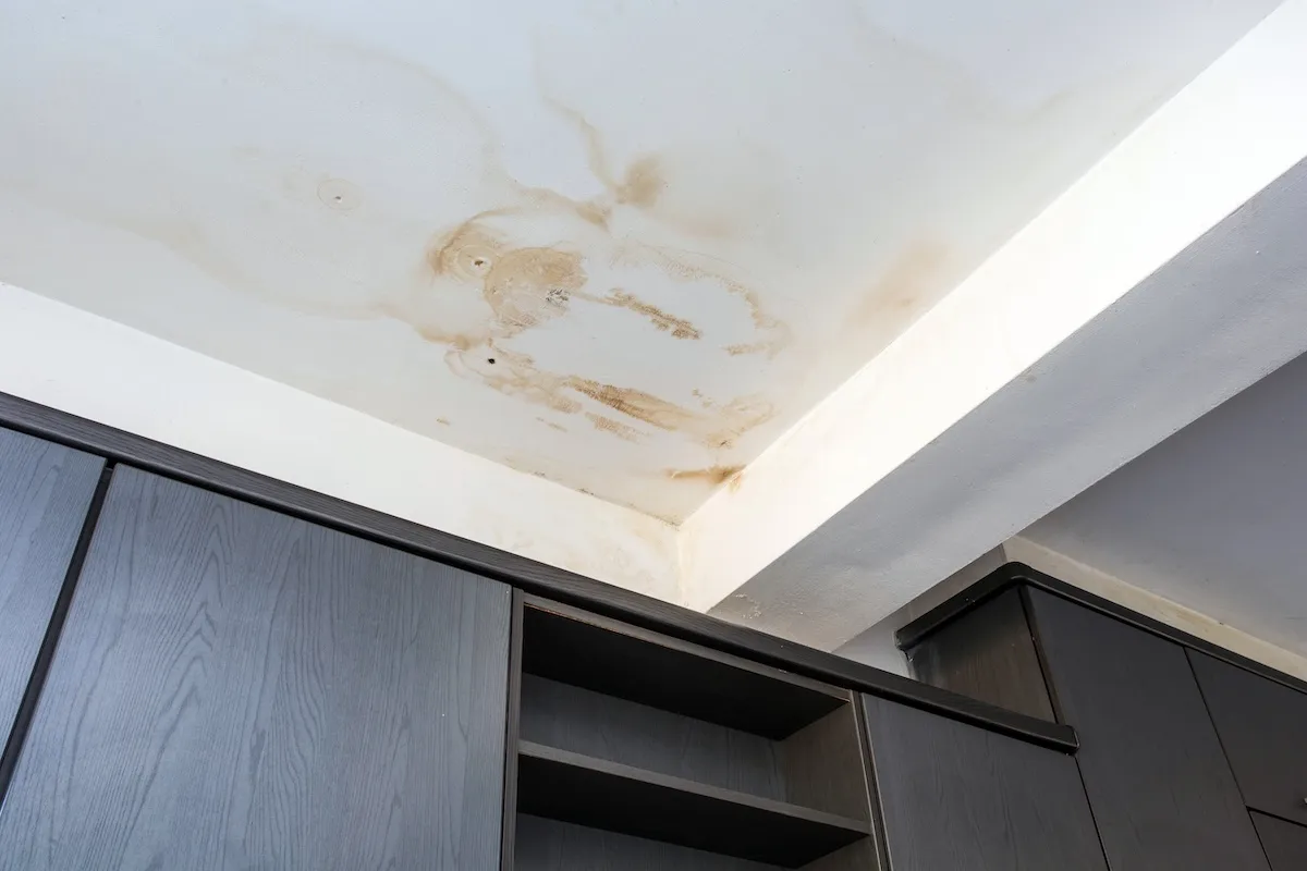 A ceiling stain from a leaky toilet on an upper level in a home.