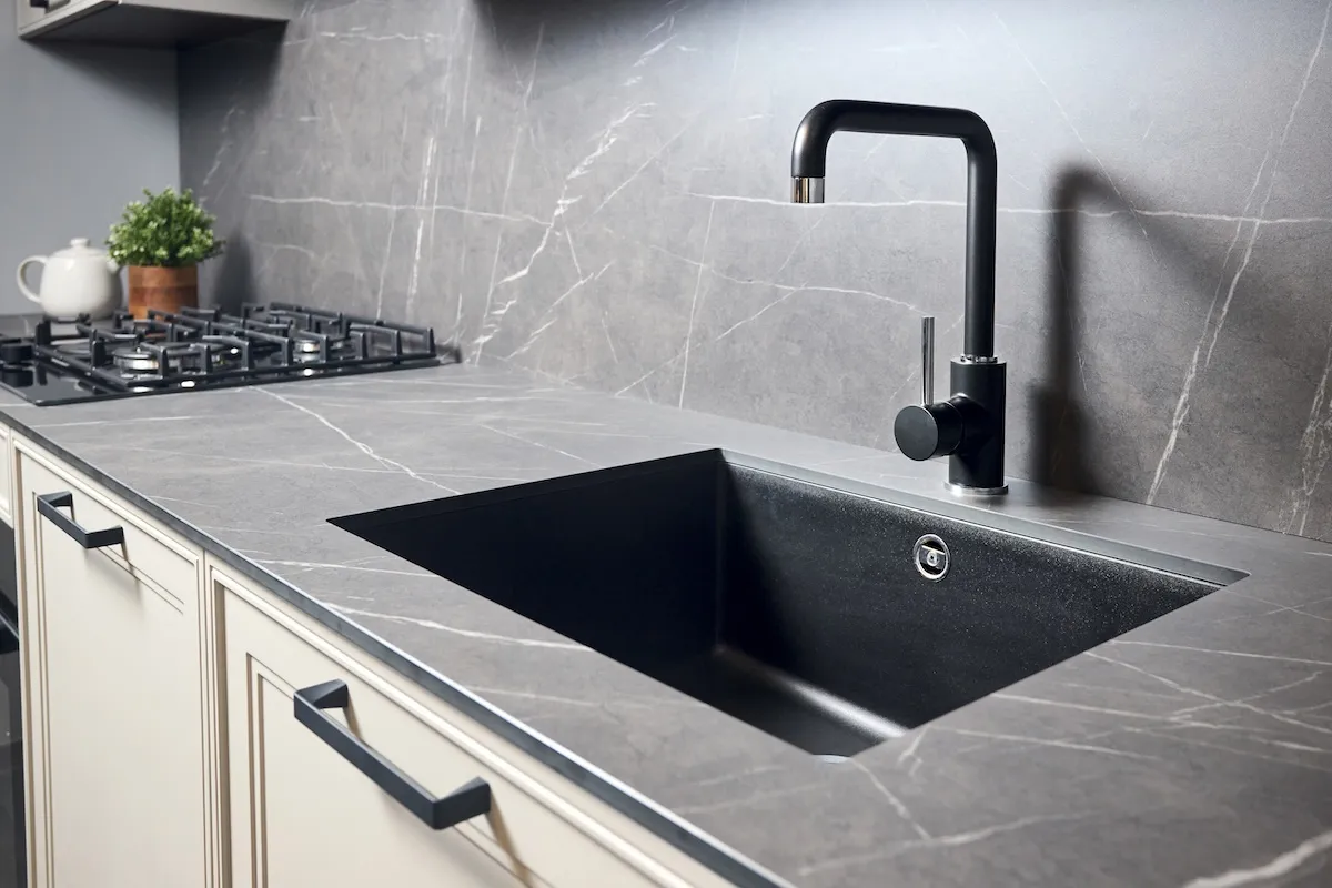 Gray soapstone countertop and backsplash installed in a kitchen.